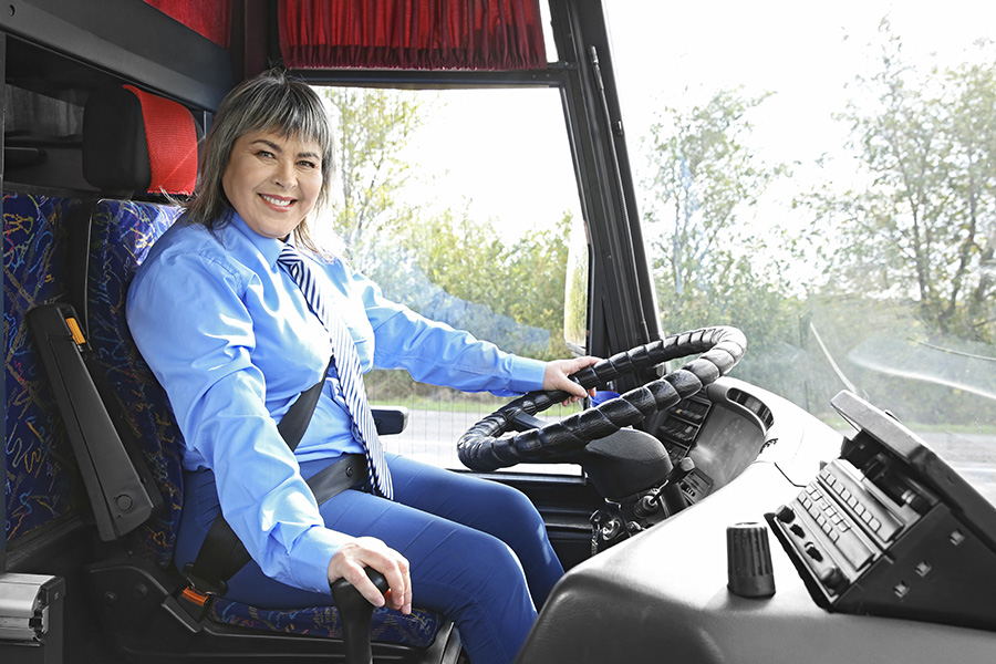 specificskills_b a female smiling driving a bus