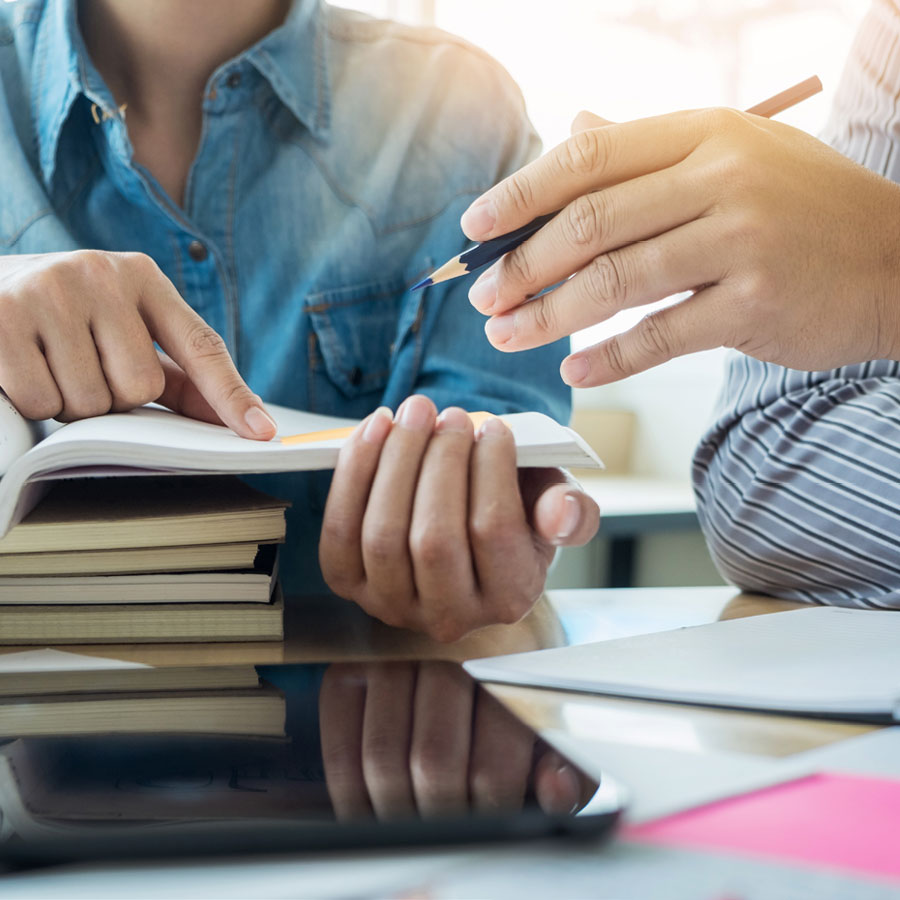 FeaturedImage8 Two adults studying and discussing at table