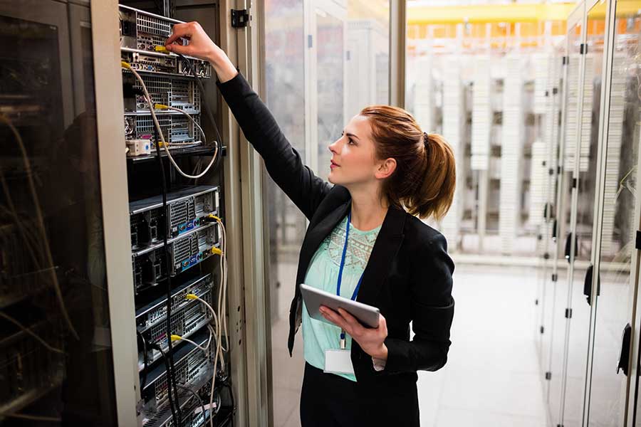 shutterstock_585381311 female engineers working in comms room with servers