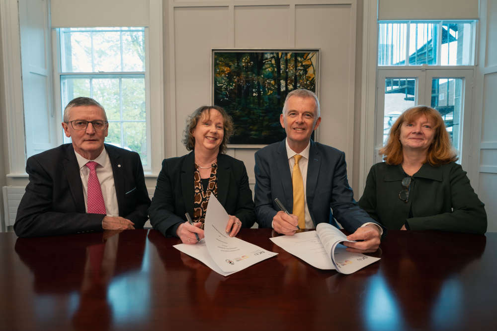 LMETB and DCU representatives sign a formal agreement at a meeting table in DIFE.